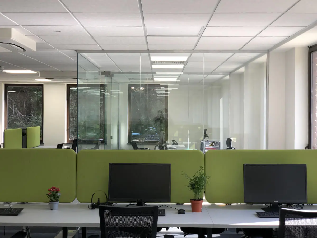 Office with glass partitions and desk with dividing screens