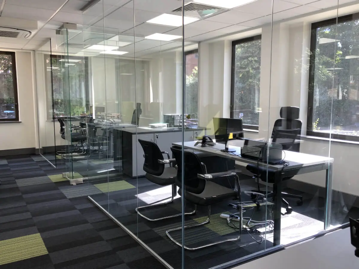 Private office space with glass partitions desks and chairs
