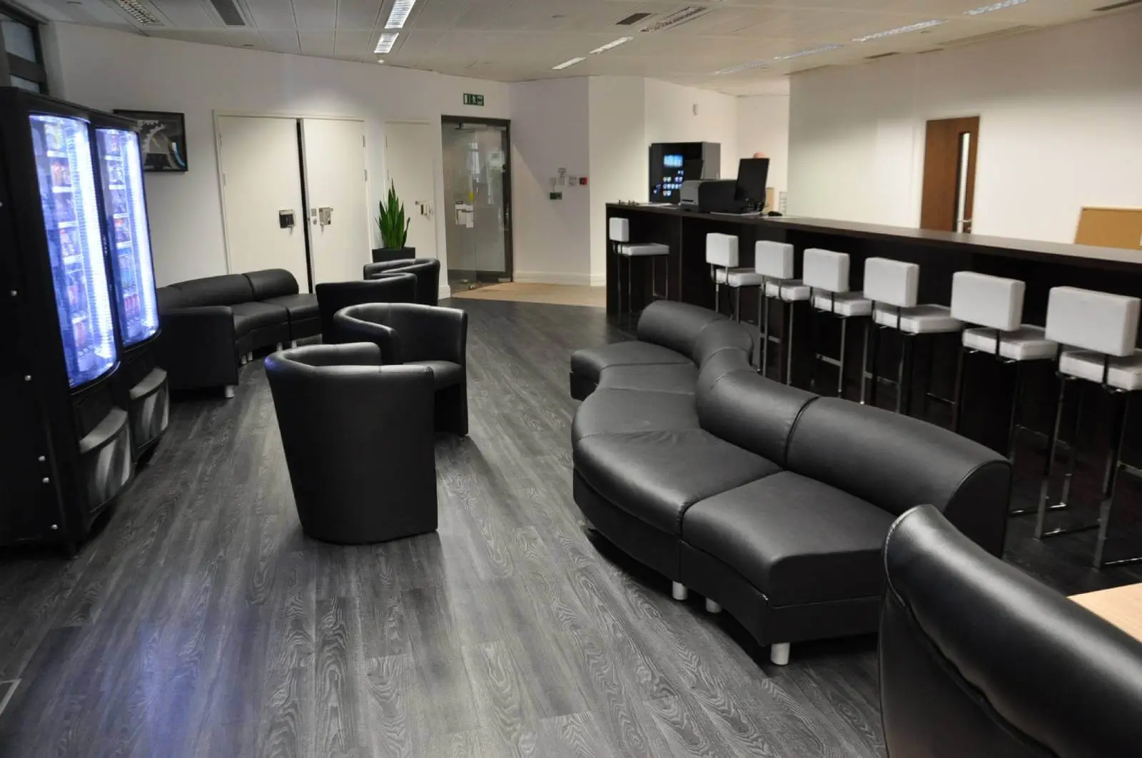 Bordeux office space with designer furniture, laminated wood floor, suspended grid ceiling, and glass partitions 10