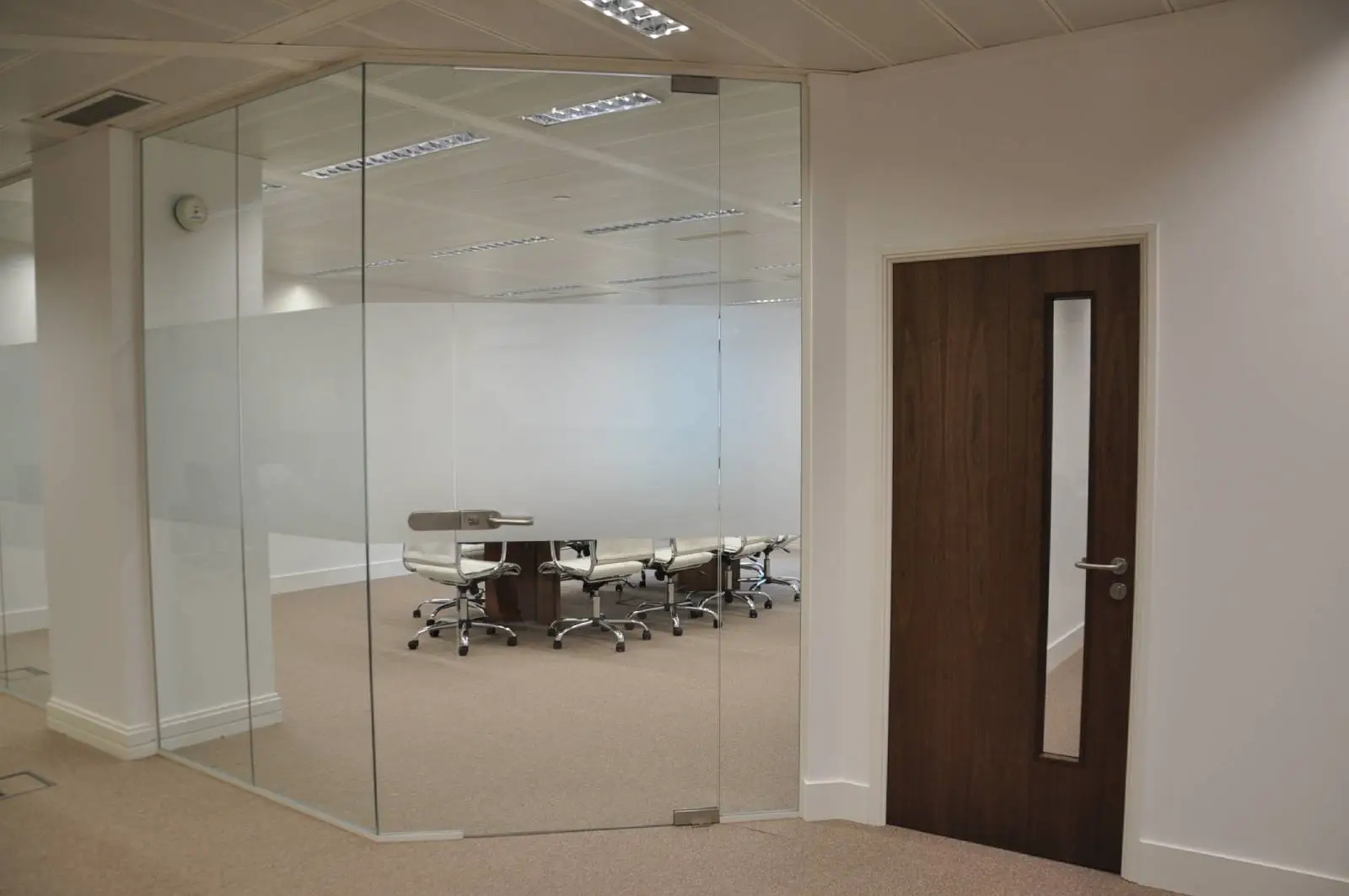 Bordeux office space with designer furniture, laminated wood floor, suspended grid ceiling, and glass partitions 20