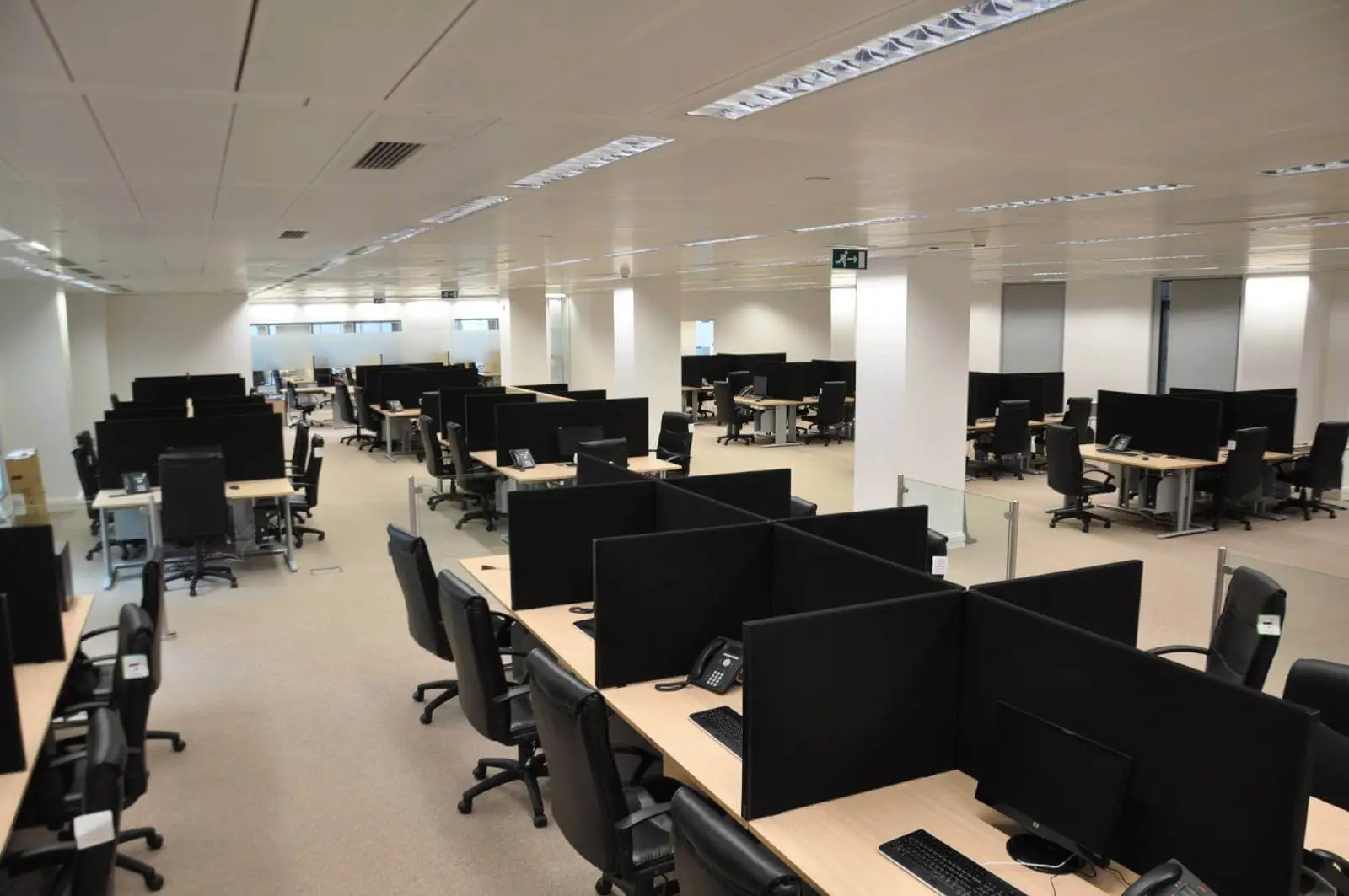 Bordeux office space with designer furniture, laminated wood floor, suspended grid ceiling, and glass partitions 4