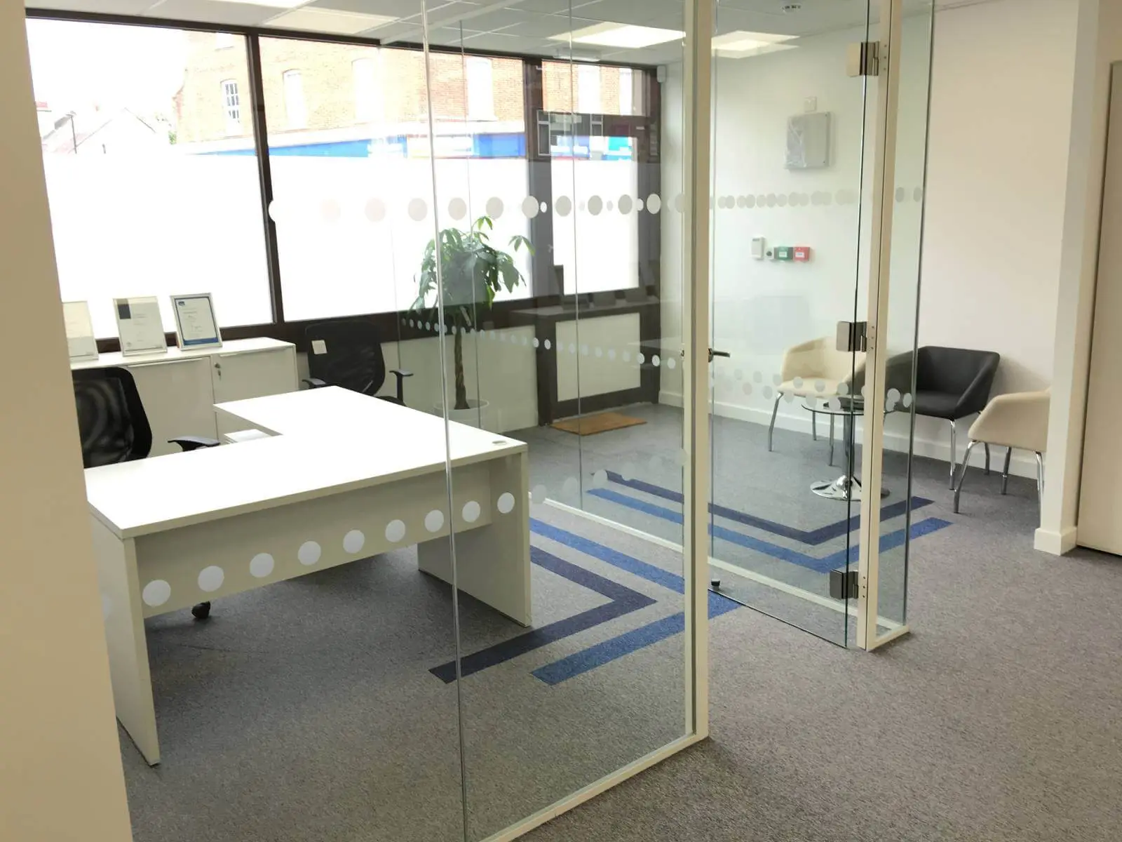 Care Expertise health care space with designer furniture, suspended grid ceiling, carpet tile flooring and glass partitions 3