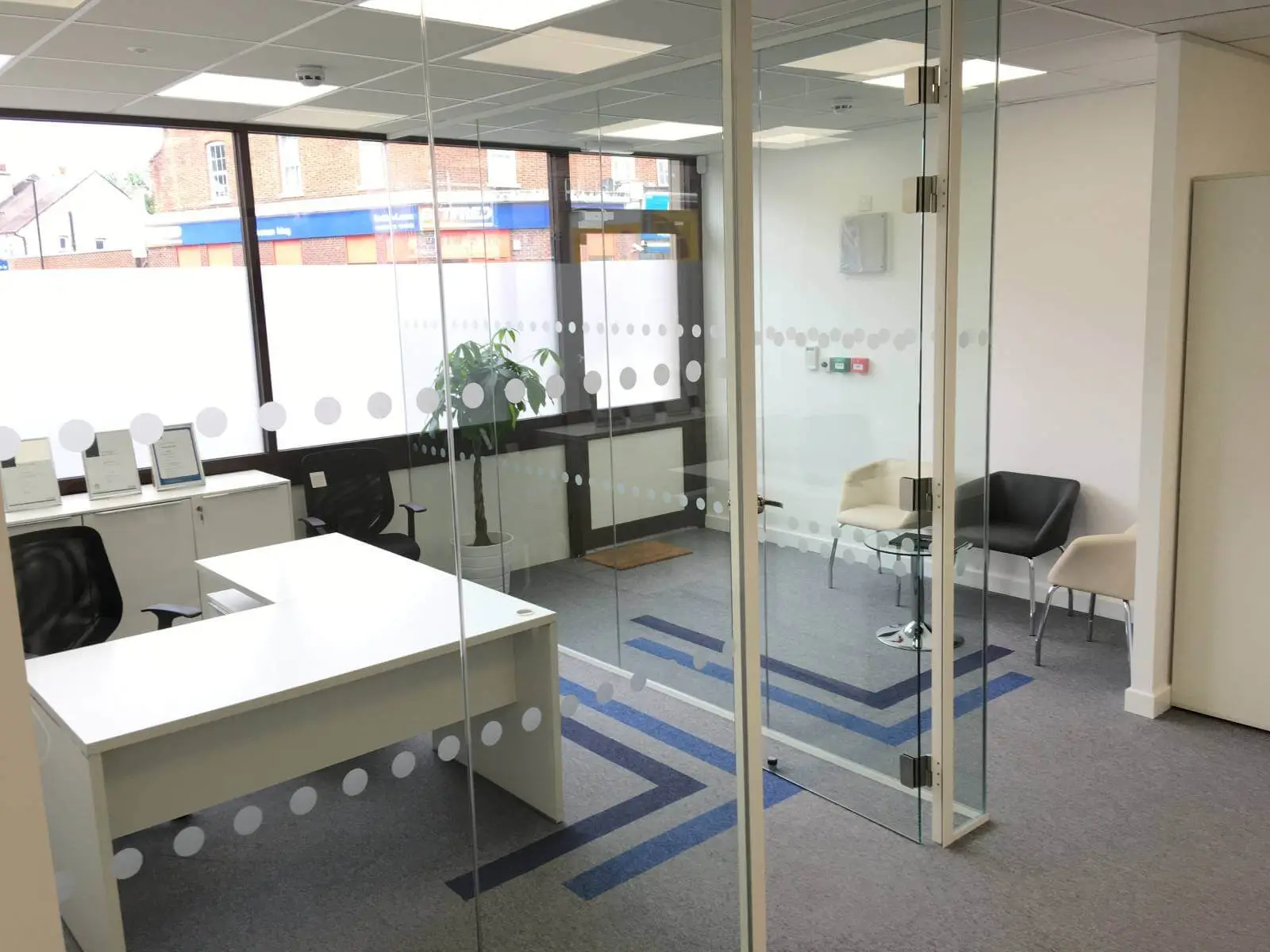 Care Expertise health care space with designer furniture, suspended grid ceiling, carpet tile flooring and glass partitions 4