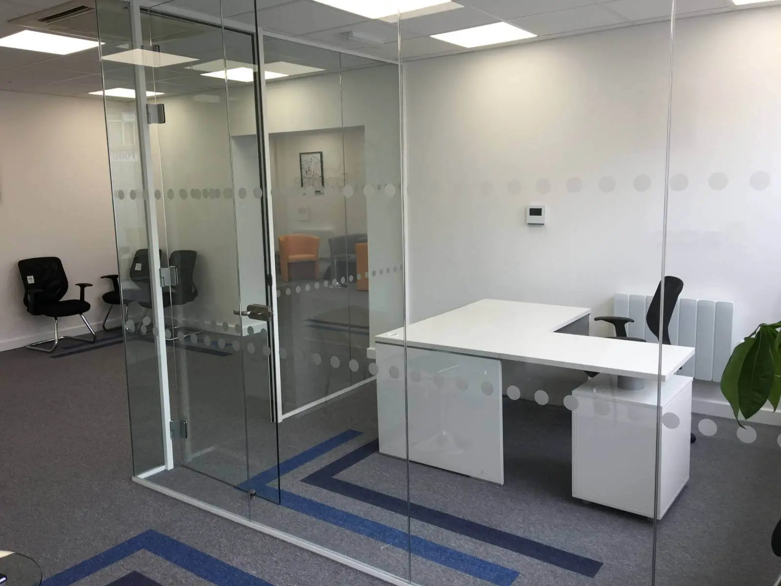 Care Expertise health care space with designer furniture, suspended grid ceiling, carpet tile flooring and glass partitions 5