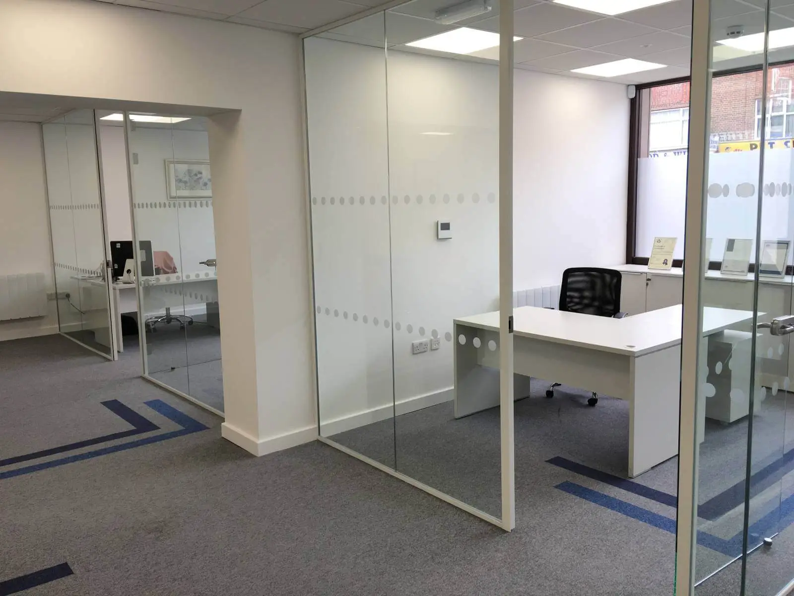 Care Expertise health care space with designer furniture, suspended grid ceiling, carpet tile flooring and glass partitions 7