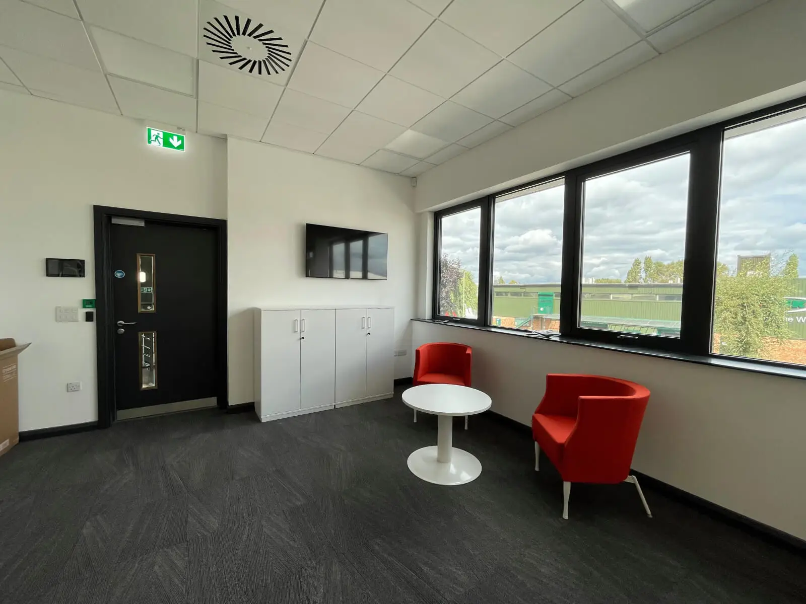 EFL office space with designer back to back desks, chairs, laminated wood flooring, suspended grid ceiling and glass partitions 11