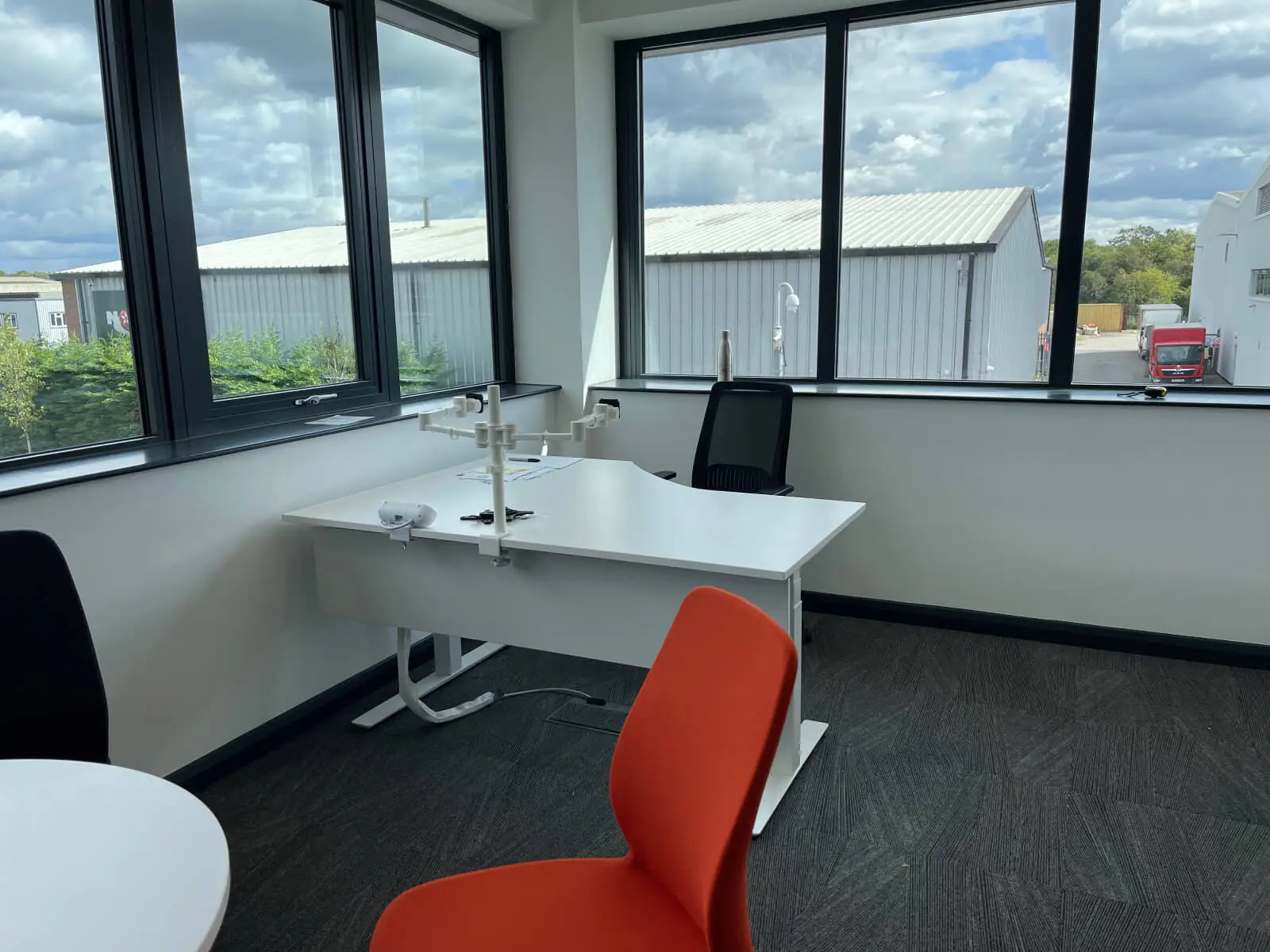 EFL office space with designer back to back desks, chairs, laminated wood flooring, suspended grid ceiling and glass partitions 21