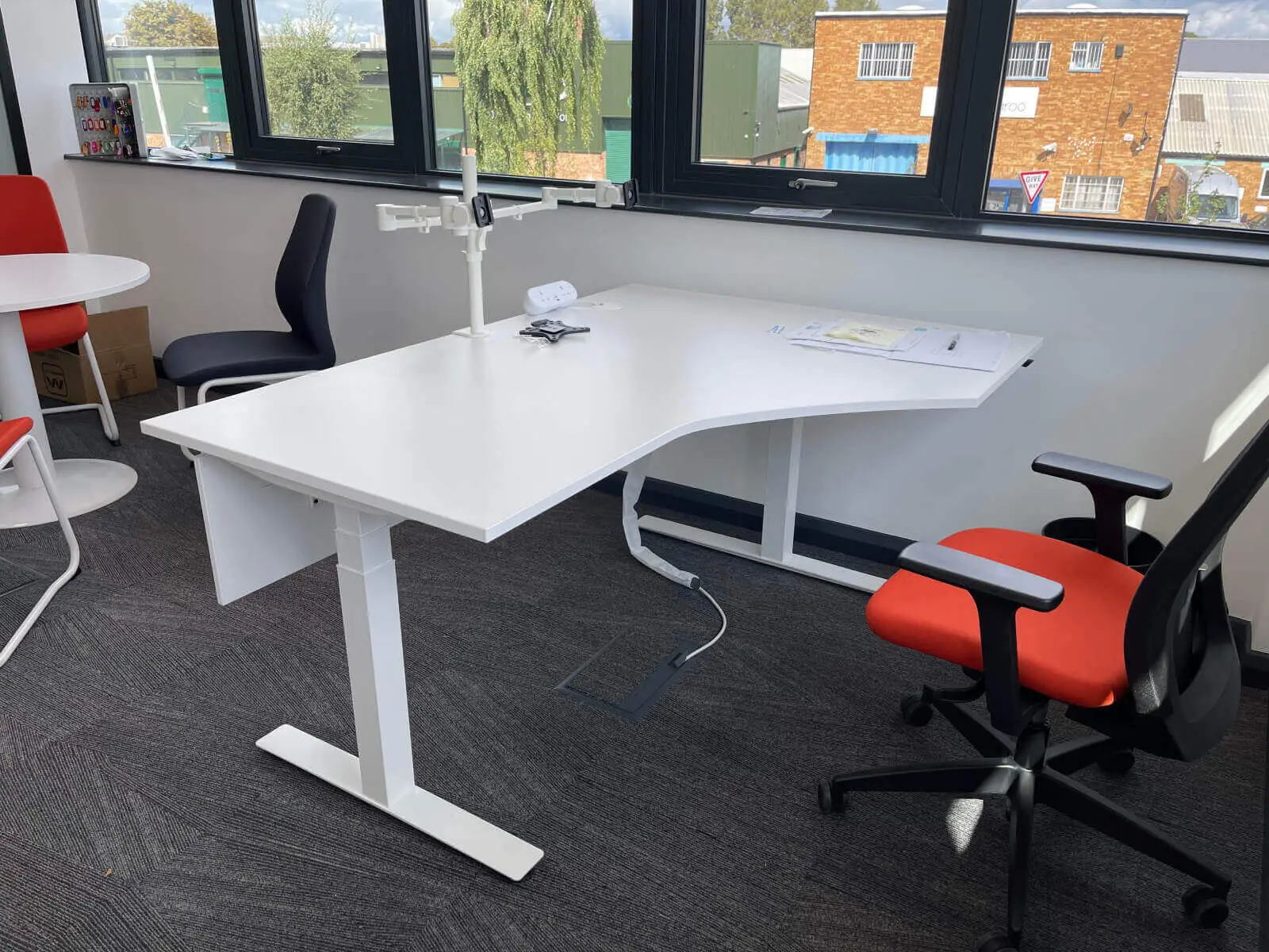 EFL office space with designer back to back desks, chairs, laminated wood flooring, suspended grid ceiling and glass partitions 22