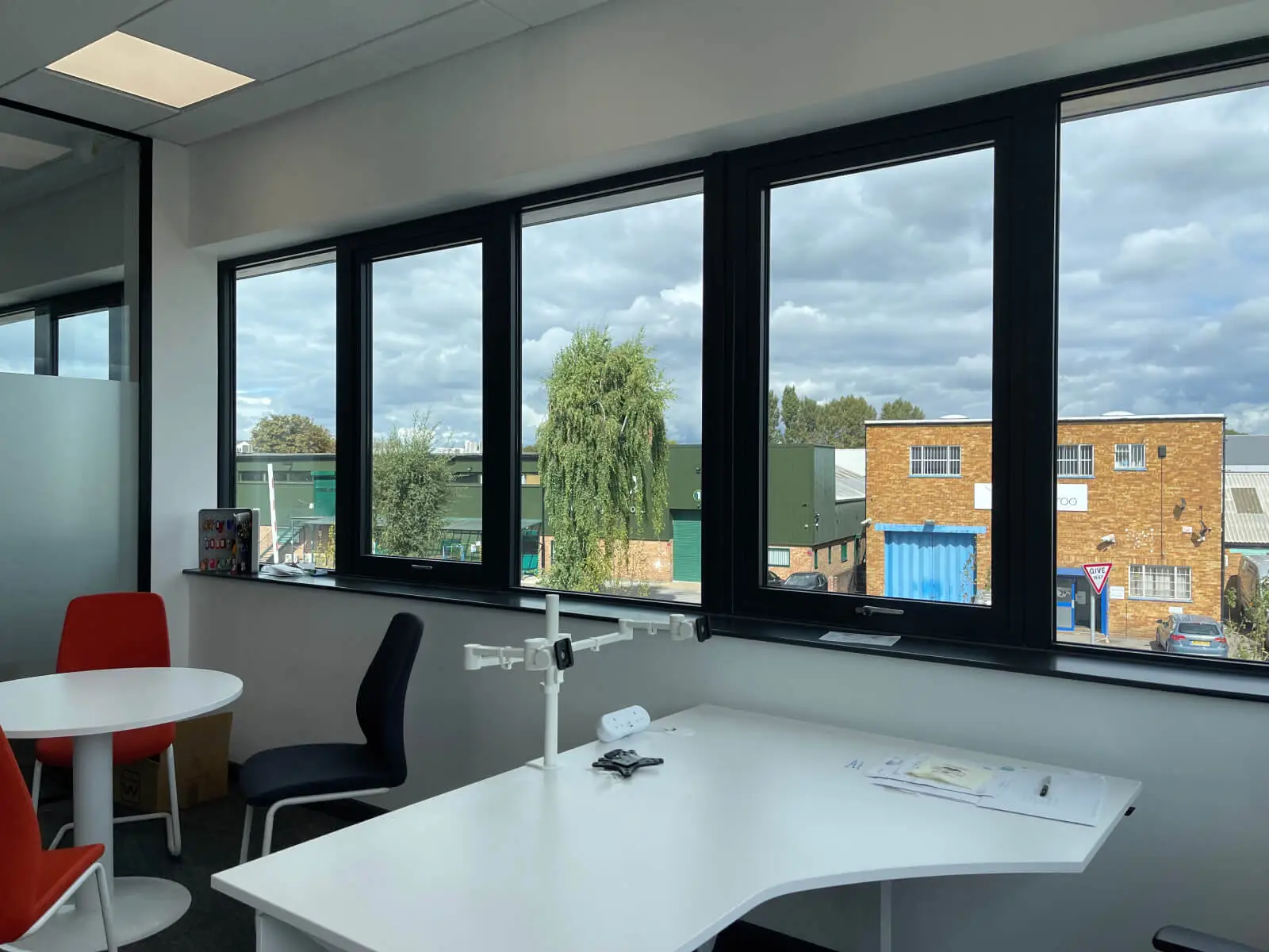 EFL office space with designer back to back desks, chairs, laminated wood flooring, suspended grid ceiling and glass partitions 23