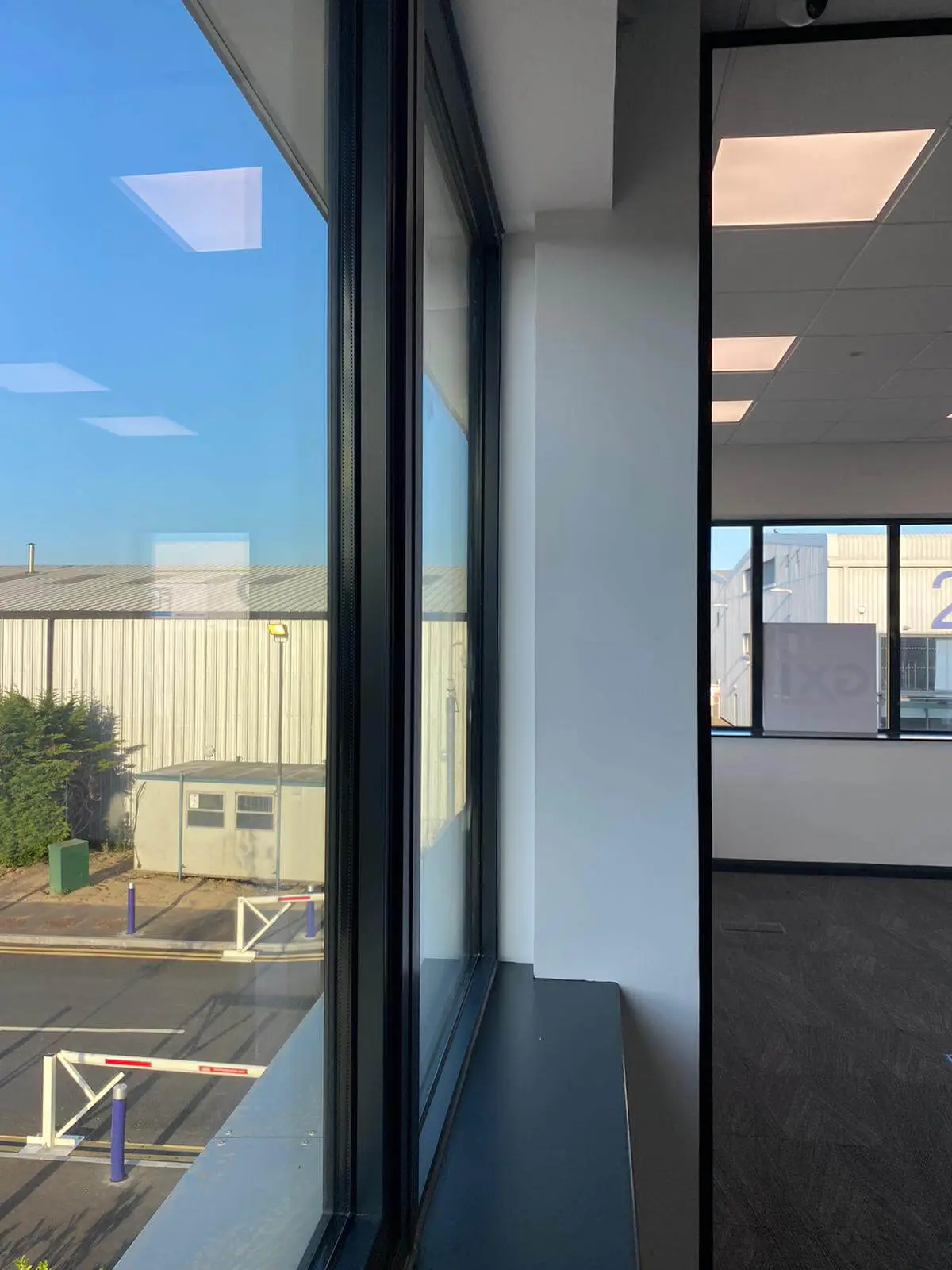 EFL office space with designer back to back desks, chairs, laminated wood flooring, suspended grid ceiling and glass partitions 42