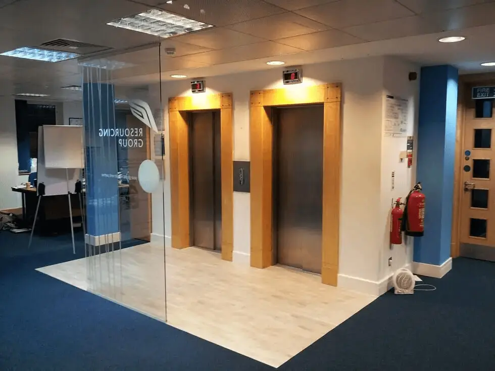 hcig office work space with designer furniture, glass partitions, suspended grid ceiling, and designer flooring 7
