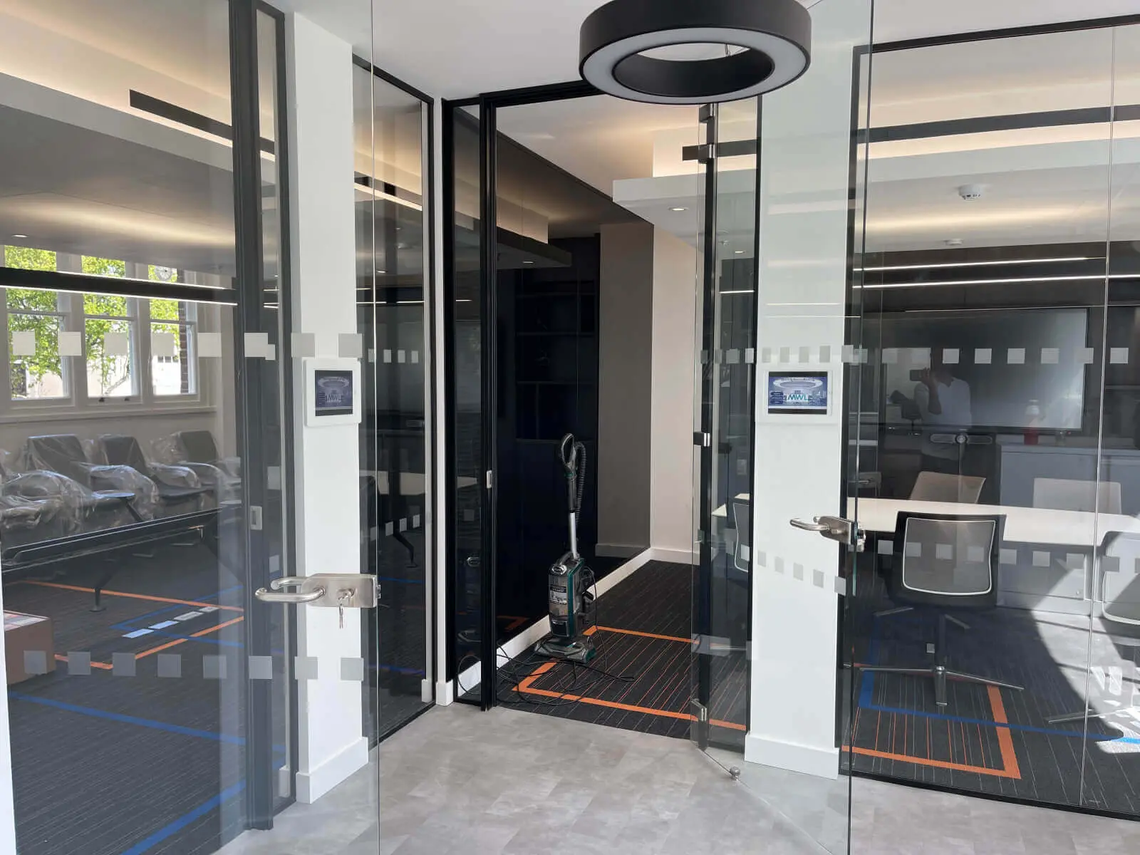 Mendik Waring office space design with designer flooring, acoustic ceiling and black framed glass partitions 10