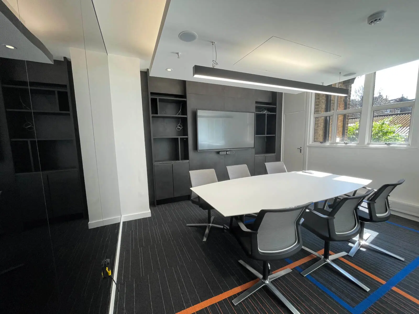 Mendik Waring office space design with designer flooring, acoustic ceiling and black framed glass partitions 11