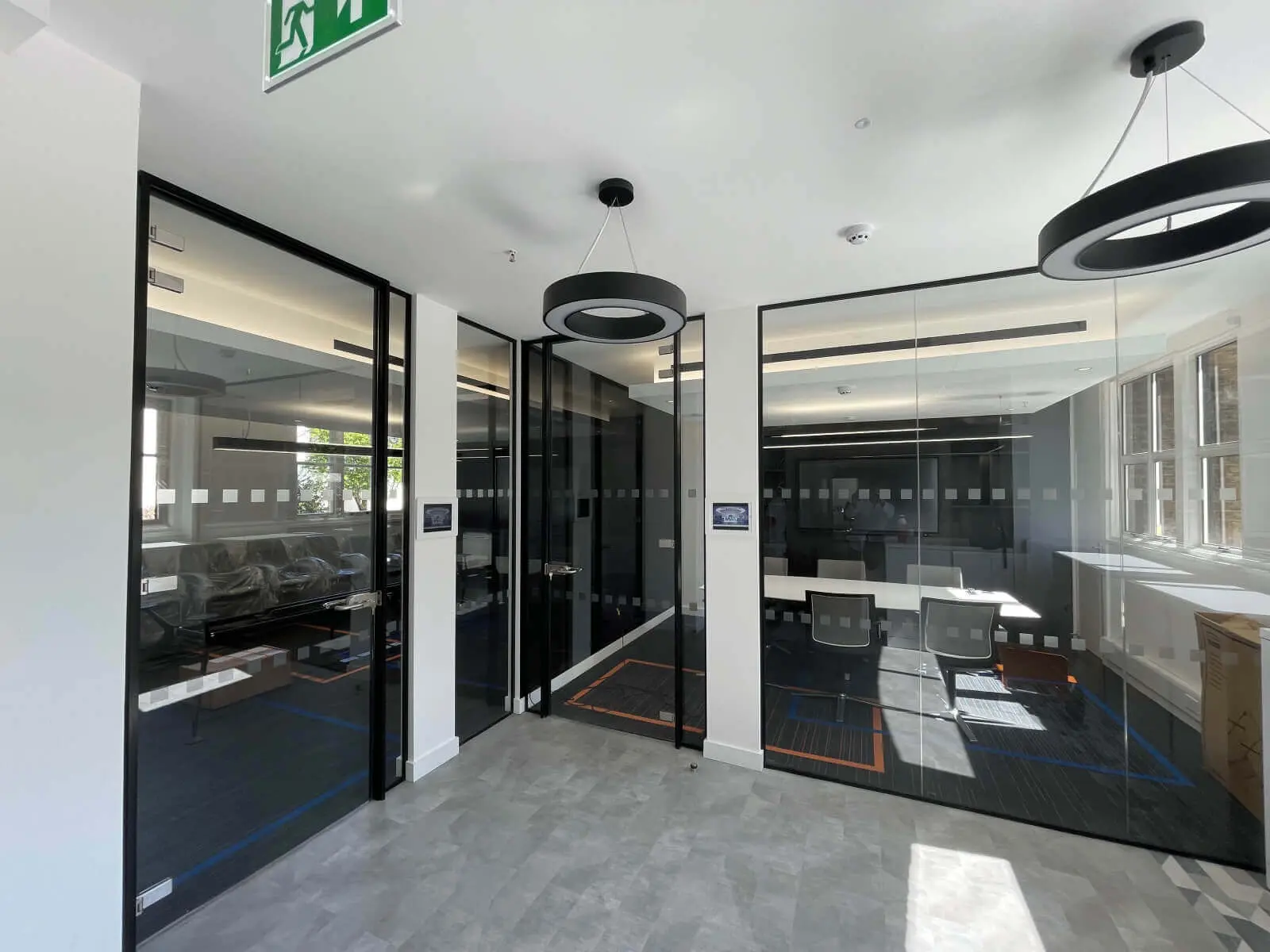 Mendik Waring office space design with designer flooring, acoustic ceiling and black framed glass partitions 12