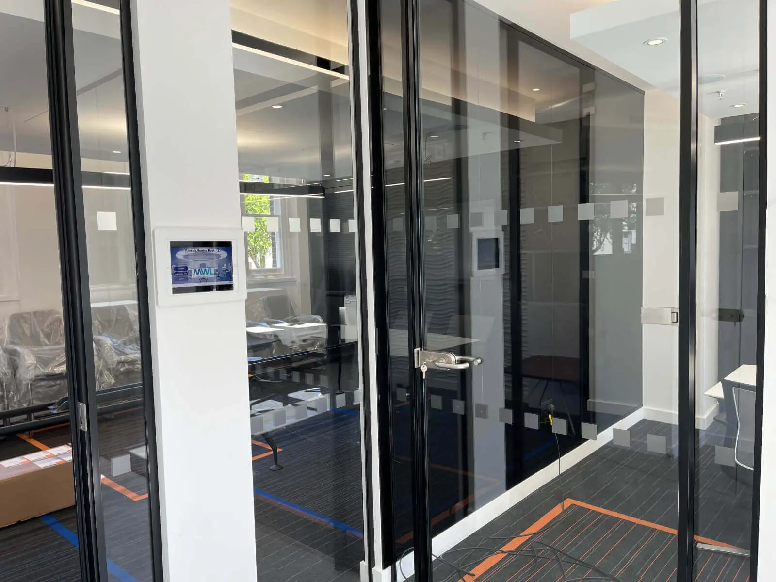 Mendik Waring office space design with designer flooring, acoustic ceiling and black framed glass partitions 14