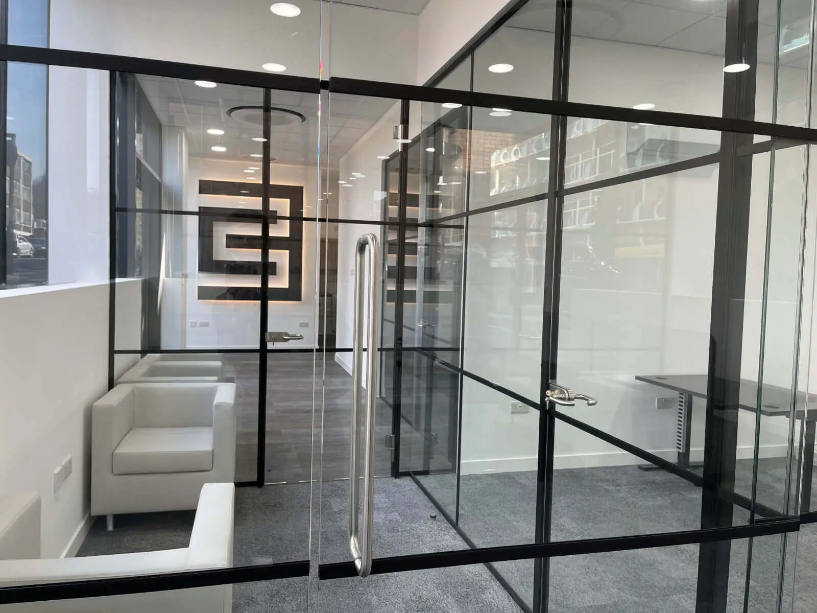 Carter Bond space design with suspended grid ceiling black framed glass partitions