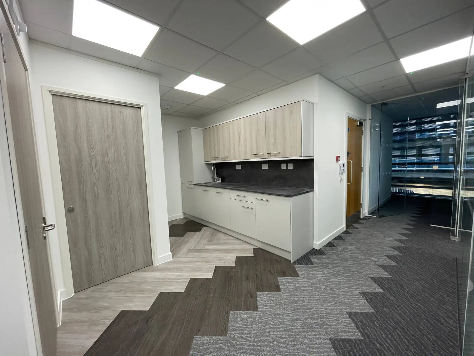 Hemsley Miller office space with designer flooring, funriture and single glazed glass partitions 14