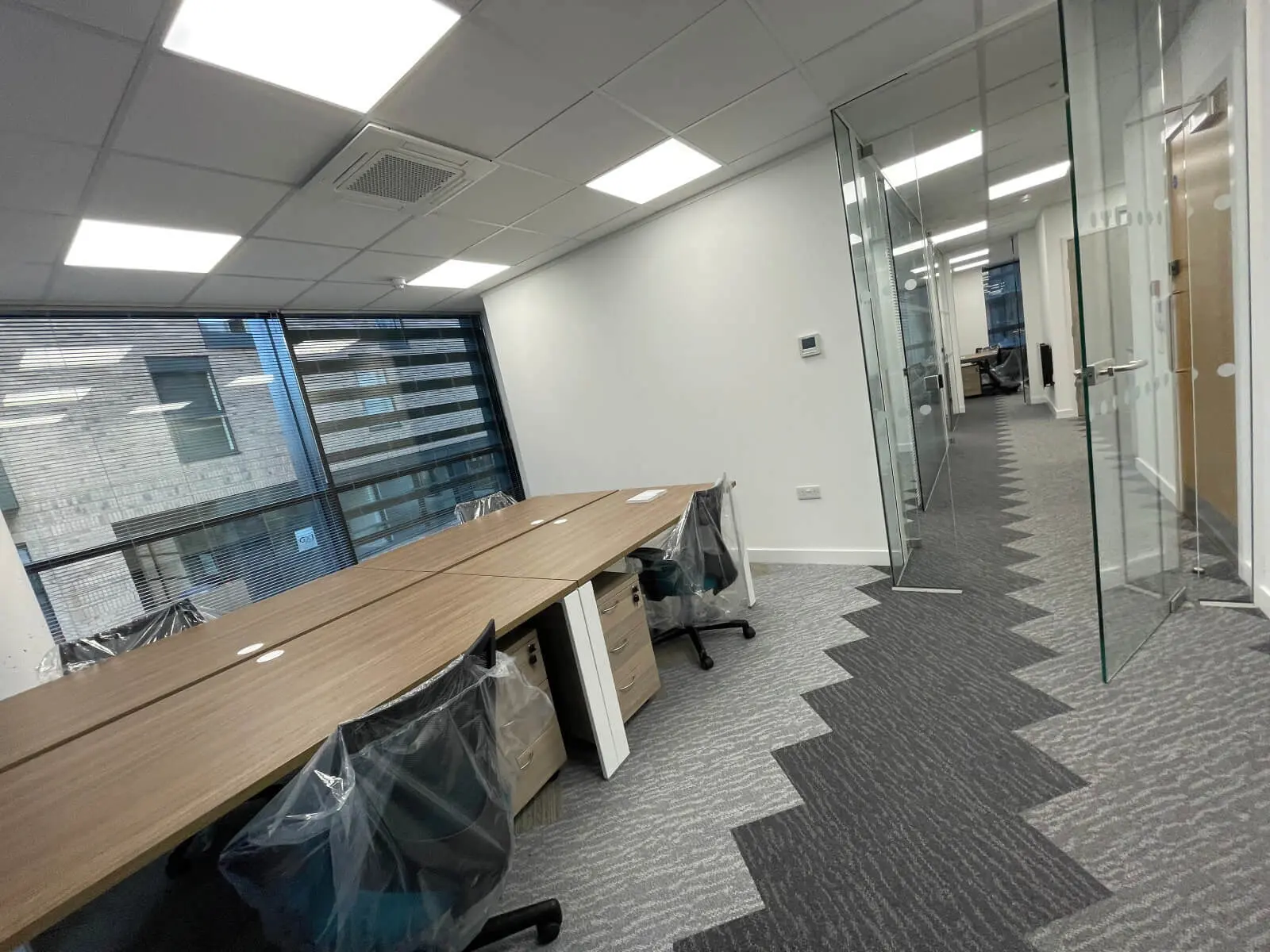 Hemsley Miller office space with designer flooring, funriture and single glazed glass partitions 15